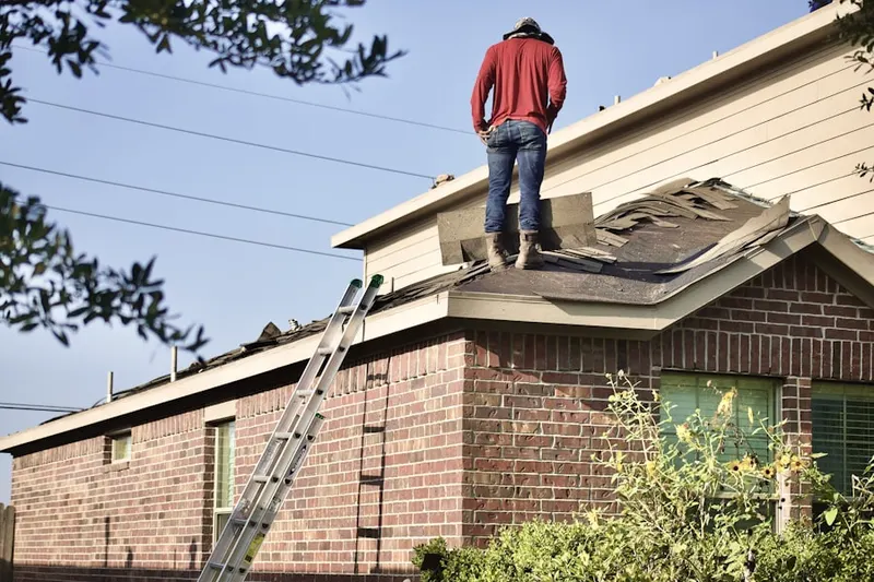 Professional roofer working on a residential roof in Bear Tavern